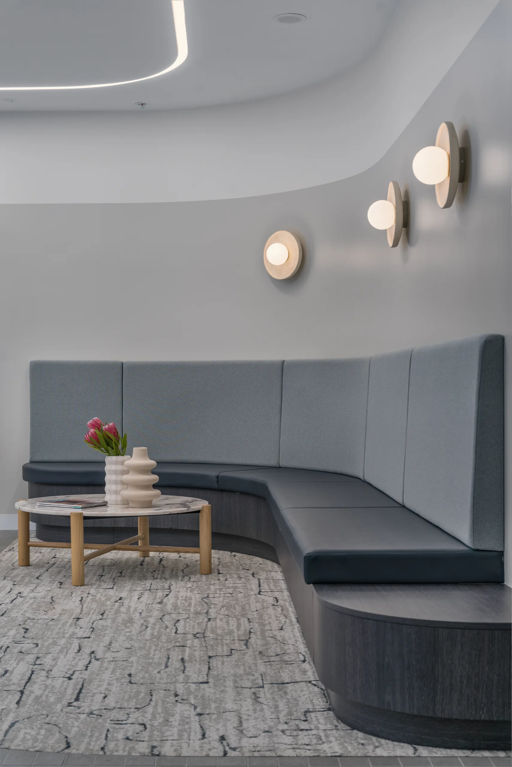 Curved banquette lounge with wall sconces, IPG interior fitout
